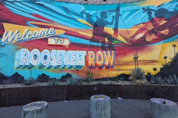 A colorful mural with "Welcome to Roosevelt Row," featuring artistic silhouettes and desert plants in the foreground.